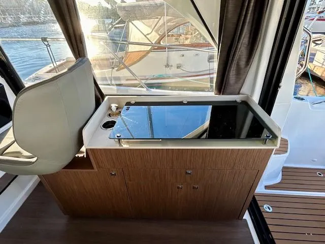 Sea Of Dreams Yacht Photos Pics 2024 Beneteau Antares 9 interior with sleek wooden cabinetry and modern seating.