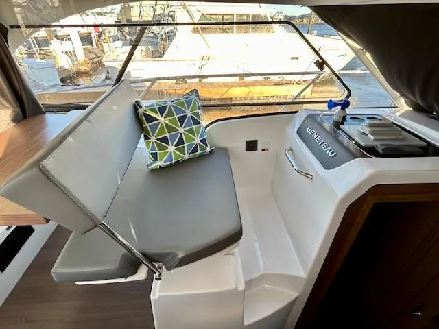 Sea Of Dreams Yacht Photos Pics 2024 Beneteau Antares 9 interior with seating, cushion, and helm station.