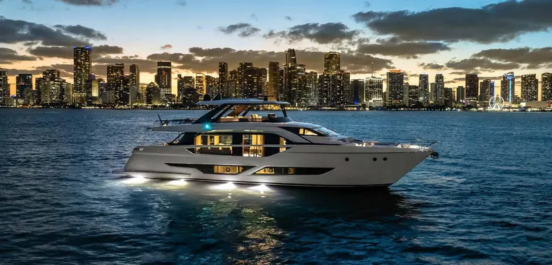  Yacht Photos Pics 2025 Ferretti Yachts 860 cruising at sunset with city skyline backdrop.