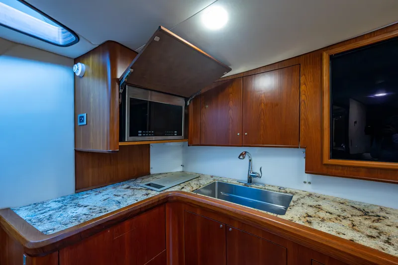 Flying B Yacht Photos Pics Luxurious yacht kitchen with granite countertops and wooden cabinets, 2018 French Yachts Custom Express Sportfish.