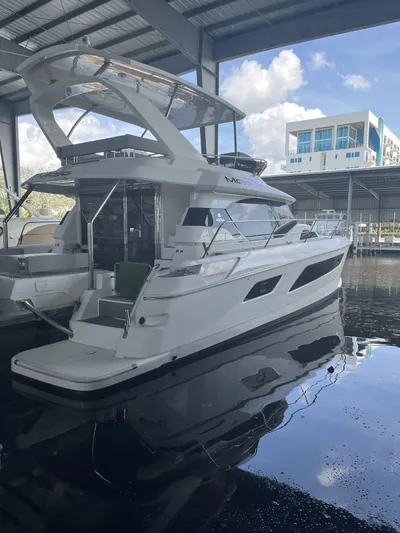Mojo Yacht Photos Pics 2020 Aquila 44 Yacht docked in a covered marina, reflecting on calm water.