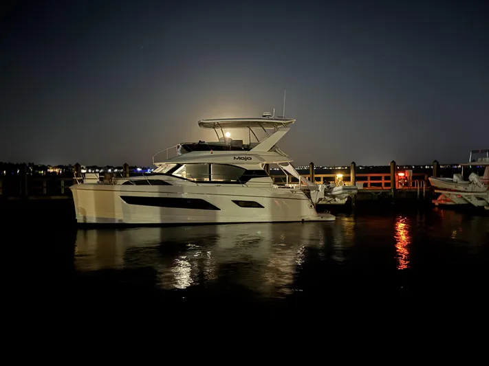 Mojo Yacht Photos Pics Aquila 44 Yacht 2020 docked at night, reflecting on calm water.