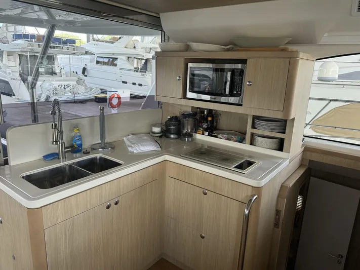 Mojo Yacht Photos Pics Modern kitchen interior on 2020 Aquila 44 Yacht with sink, microwave, and storage.