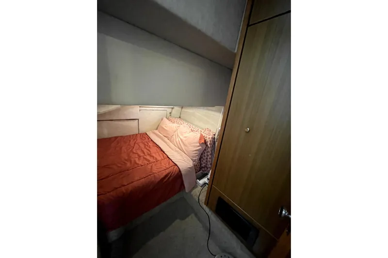 Yeah Buddy Yacht Photos Pics Cozy bedroom in 2001 Bayliner 3988 Command Bridge Motoryacht with red bedding and wooden cabinet.