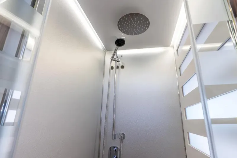 No Name Yacht Photos Pics Modern shower interior on 2019 Azimut S7 yacht, featuring sleek design and overhead showerhead.