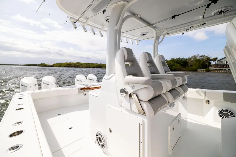  Yacht Photos Pics 2023 Freeman 43 boat interior with seating and multiple outboard engines on a calm waterway.