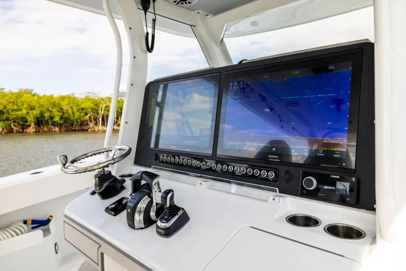  Yacht Photos Pics 2023 Freeman 43 boat dashboard with dual screens and controls, near water and trees.