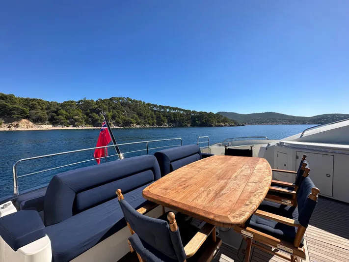 Low Profile Yacht Photos Pics Sunseeker Predator 82 yacht deck with wooden table and ocean view, 2007 model.