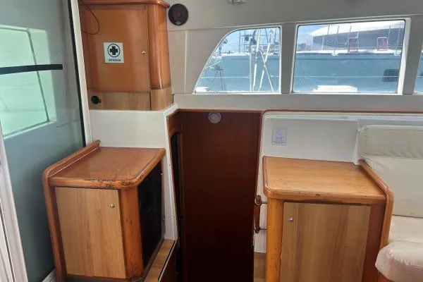 Dos Yacht Photos Pics Interior of a 2005 Lagoon 440 yacht, featuring wooden cabinetry and large windows.