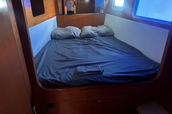 Dos Yacht Photos Pics Cozy cabin interior of 2005 Lagoon 440 catamaran with double bed and pillows.