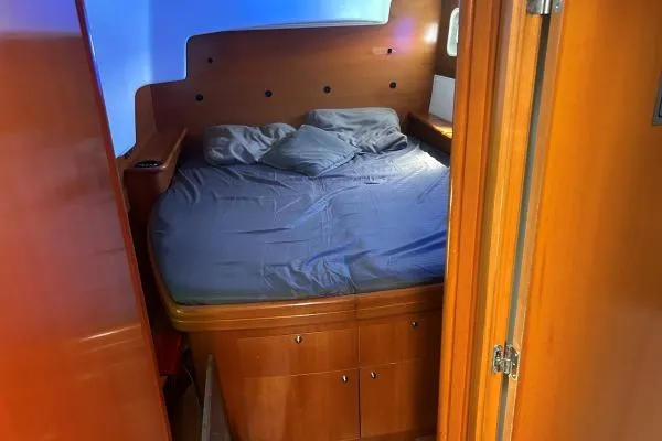 Dos Yacht Photos Pics Cozy cabin interior of 2005 Lagoon 440 catamaran with wooden finish and comfortable bedding.