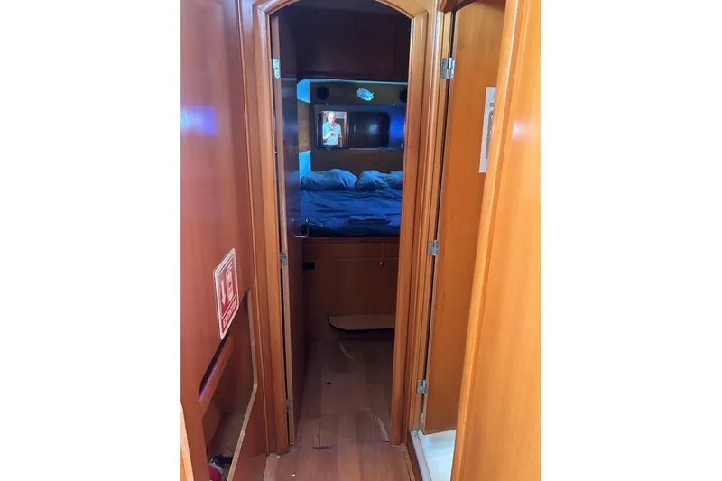 Dos Yacht Photos Pics Interior view of 2005 Lagoon 440 yacht cabin with wooden finish and cozy bed.