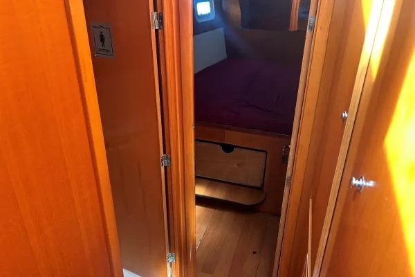 Dos Yacht Photos Pics Interior cabin view of 2005 Lagoon 440 yacht with wooden finish and cozy sleeping area.