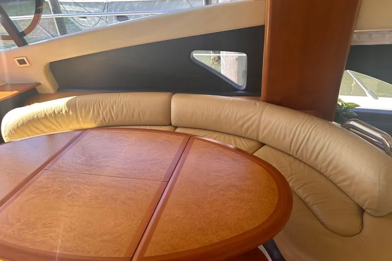 Splendor Yacht Photos Pics Luxurious interior of 2007 Azimut 55E yacht with curved leather seating and wooden table.