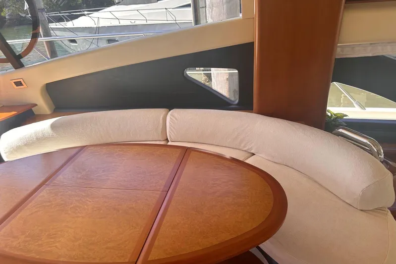 Splendor Yacht Photos Pics Luxurious interior of a 2007 Azimut 55E yacht with elegant wood table and curved seating.