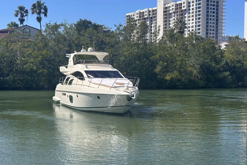 Splendor Yacht Photos Pics 2007 Azimut 55E yacht cruising on a calm river with lush greenery and buildings in the background.