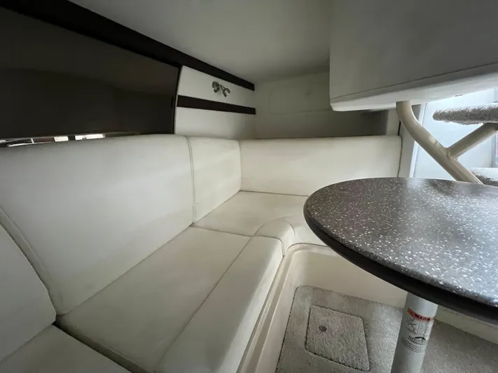  Yacht Photos Pics Interior of 2012 Cruisers Yachts 350 Express with white seating and round table.