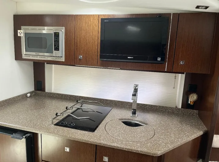  Yacht Photos Pics 2012 Cruisers Yachts 350 Express kitchen with microwave, TV, and modern countertop.