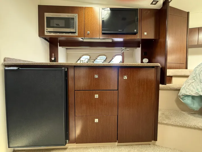  Yacht Photos Pics 2012 Cruisers Yachts 350 Express interior with kitchenette, featuring microwave and compact fridge.