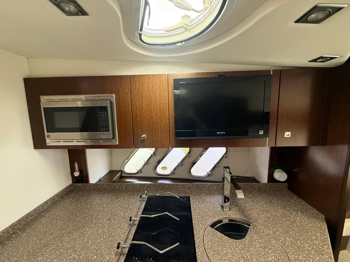  Yacht Photos Pics 2012 Cruisers Yachts 350 Express kitchen with microwave, TV, and modern fixtures.