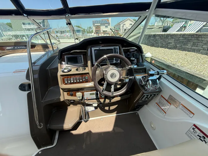  Yacht Photos Pics 2012 Cruisers Yachts 350 Express helm with steering wheel and navigation controls.