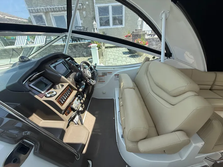  Yacht Photos Pics 2012 Cruisers Yachts 350 Express cockpit with beige seating and modern control panel.
