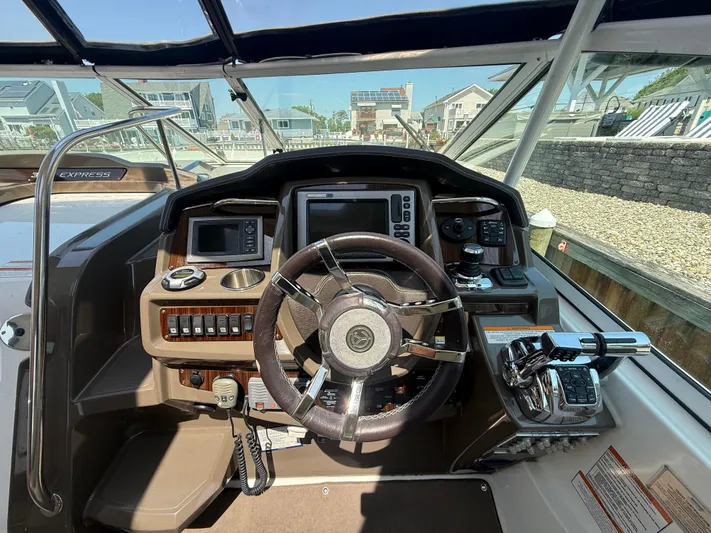  Yacht Photos Pics Cockpit of 2012 Cruisers Yachts 350 Express with steering wheel and navigation controls.