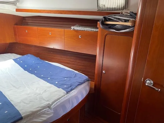 Rogue Fun Yacht Photos Pics Cozy cabin interior of 2001 Beneteau Oceanis 44 CC with wooden finish and bed.