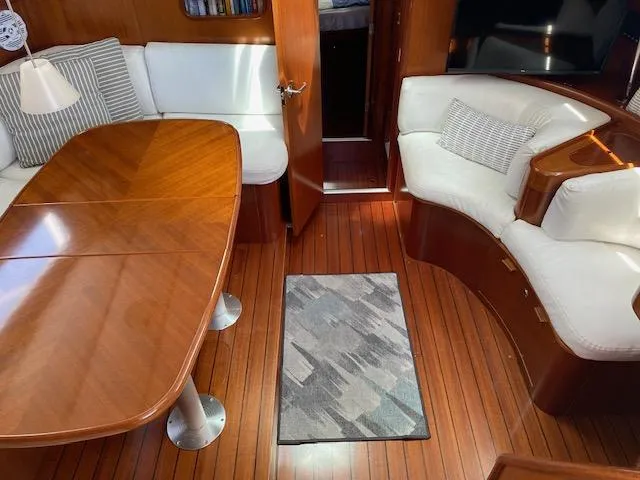 Rogue Fun Yacht Photos Pics Interior of 2001 Beneteau Oceanis 44 CC yacht with wooden flooring and white seating.