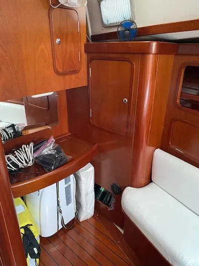 Rogue Fun Yacht Photos Pics Interior of 2001 Beneteau Oceanis 44 CC sailboat with wooden cabinetry and white seating.