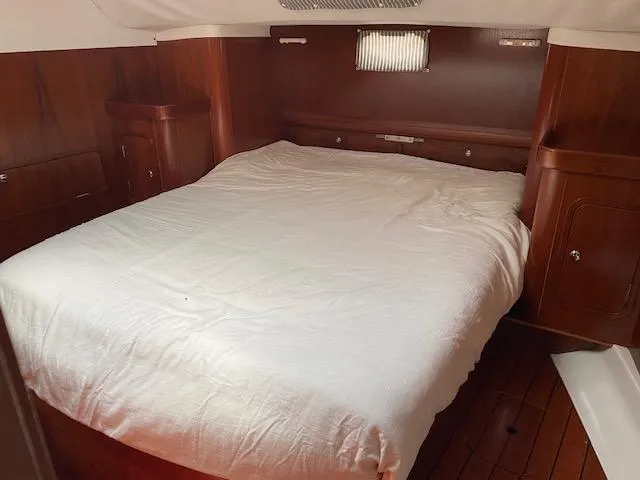Rogue Fun Yacht Photos Pics Cozy cabin interior of 2001 Beneteau Oceanis 44 CC with wooden finish and comfortable bed.