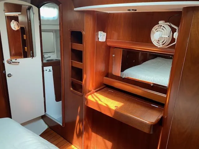 Rogue Fun Yacht Photos Pics Interior of 2001 Beneteau Oceanis 44 CC yacht with wooden cabinetry and cozy sleeping area.