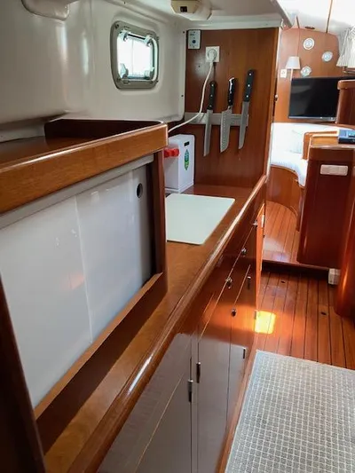 Rogue Fun Yacht Photos Pics Interior of 2001 Beneteau Oceanis 44 CC yacht, featuring a sleek kitchen area with wooden cabinetry.