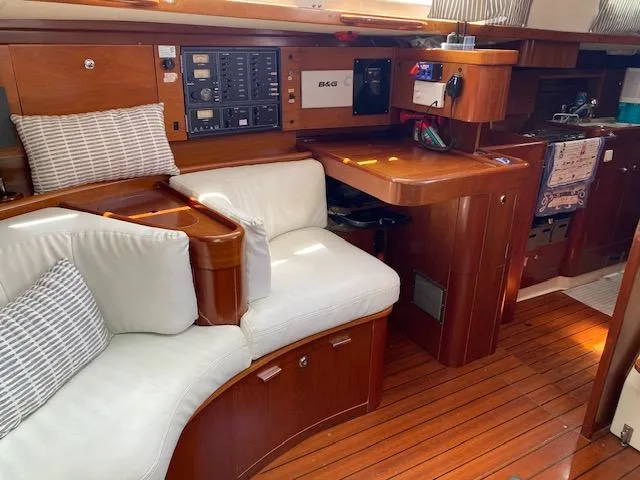 Rogue Fun Yacht Photos Pics Luxurious interior of 2001 Beneteau Oceanis 44 CC sailboat with wood finish and white seating.