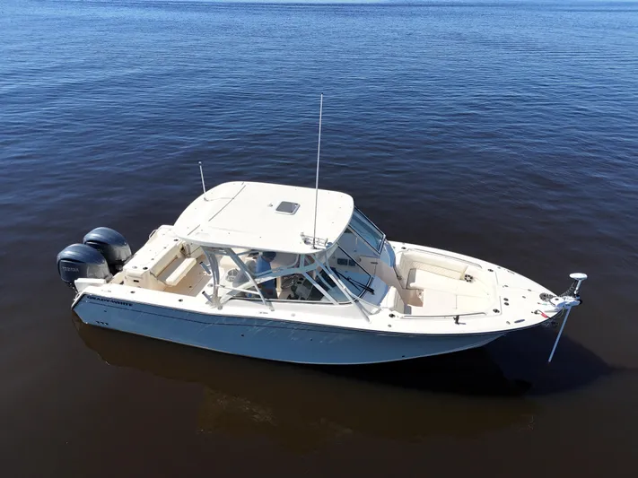  Yacht Photos Pics 2022 Grady-White Freedom 307 boat on calm water, featuring dual outboard engines.