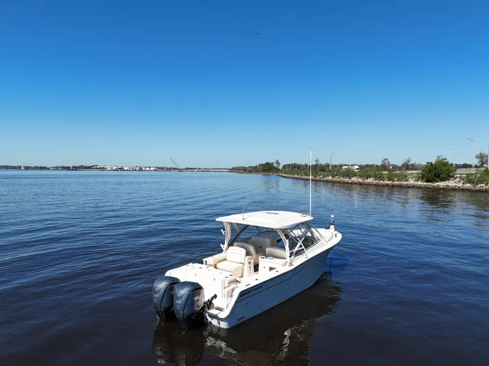  Yacht Photos Pics 2022 Grady-White Freedom 307 boat on calm water under clear blue sky.