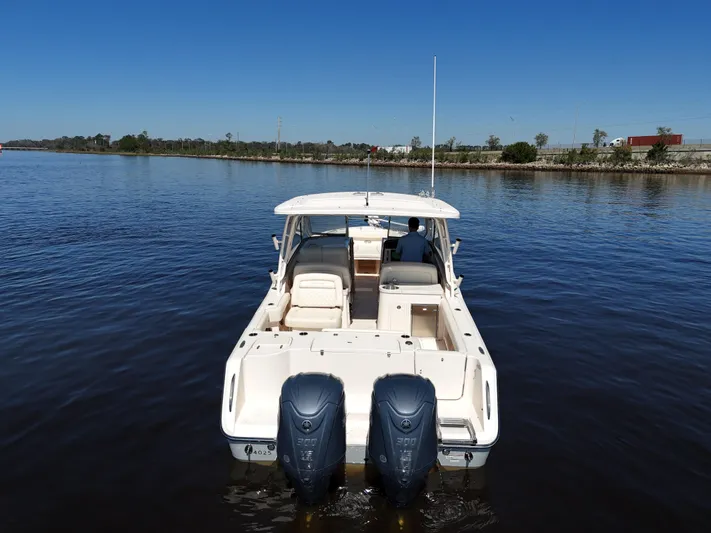  Yacht Photos Pics 2022 Grady-White Freedom 307 boat on calm water, rear view with dual engines.