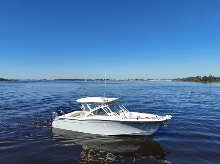  Yacht Photos Pics 2022 Grady-White Freedom 307 boat on calm blue water under clear sky.