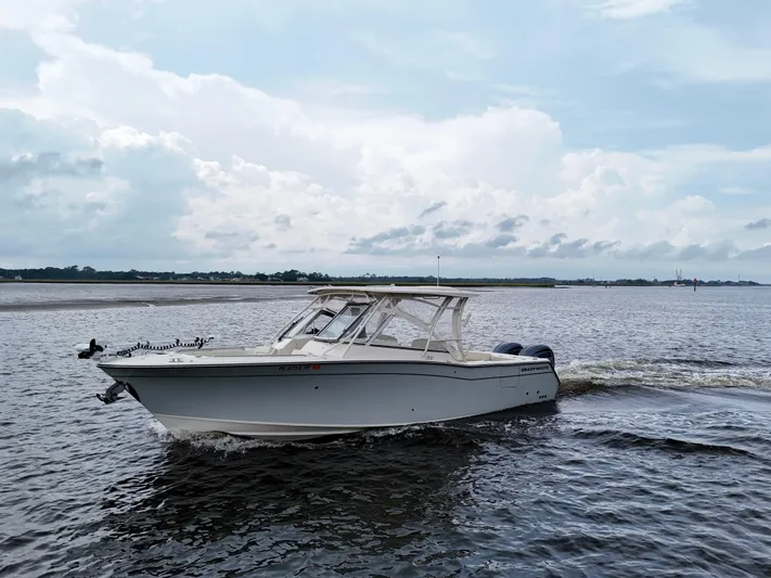  Yacht Photos Pics 2022 Grady-White Freedom 307 boat cruising on a calm, scenic waterway.