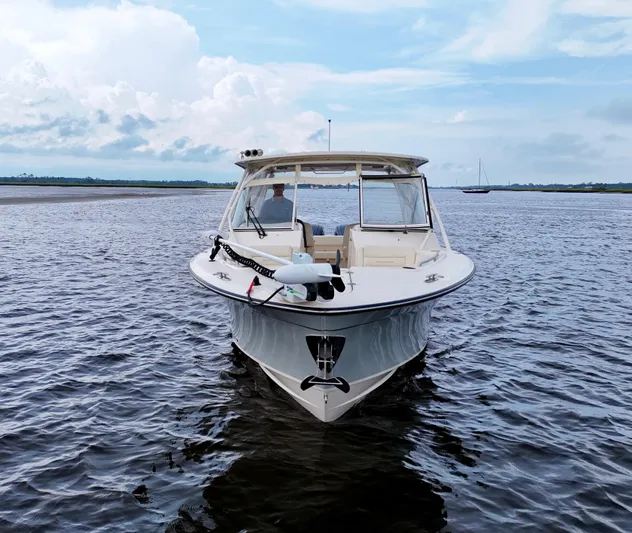  Yacht Photos Pics 2022 Grady-White Freedom 307 boat on calm water under a cloudy sky.