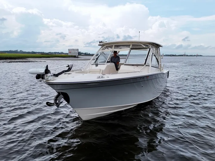  Yacht Photos Pics 2022 Grady-White Freedom 307 boat on calm water under cloudy sky.