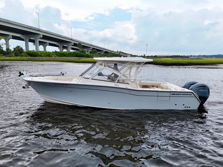  Yacht Photos Pics 2022 Grady-White Freedom 307 boat on water near a bridge, side view.