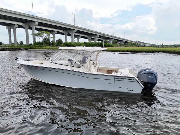  Yacht Photos Pics 2022 Grady-White Freedom 307 boat cruising under a bridge on a calm river.