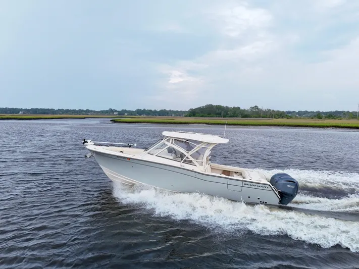  Yacht Photos Pics 2022 Grady-White Freedom 307 boat cruising on a calm river.