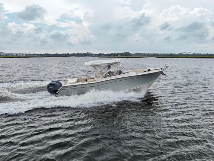  Yacht Photos Pics 2022 Grady-White Freedom 307 boat cruising on open water under cloudy skies.