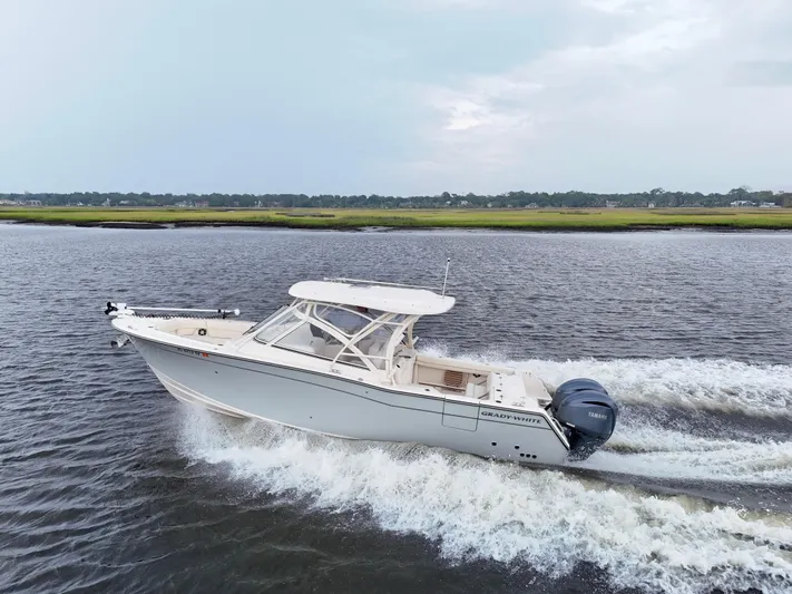  Yacht Photos Pics 2022 Grady-White Freedom 307 boat cruising on a calm river.