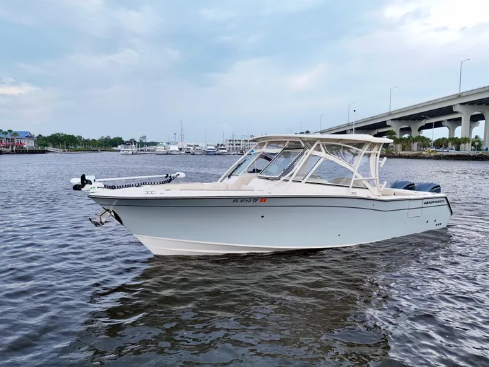  Yacht Photos Pics 2022 Grady-White Freedom 307 boat on water near a bridge and marina.