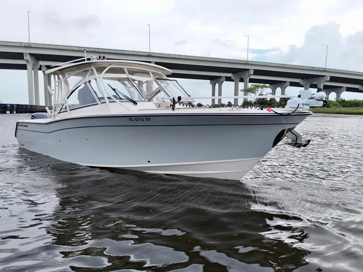  Yacht Photos Pics 2022 Grady-White Freedom 307 boat cruising under a bridge on a cloudy day.