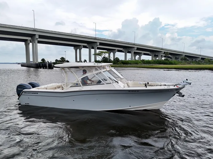  Yacht Photos Pics 2022 Grady-White Freedom 307 boat cruising under a bridge on a cloudy day.