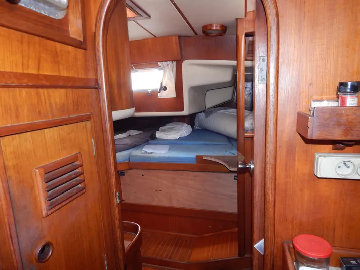  Yacht Photos Pics Interior cabin of 1983 Nautor Swan 42 sailboat with wooden finish and cozy bedding.